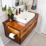 Steps to remodel a bathroom - modern decorated bathroom vanity in a modern white bathroom with natural light and plants.